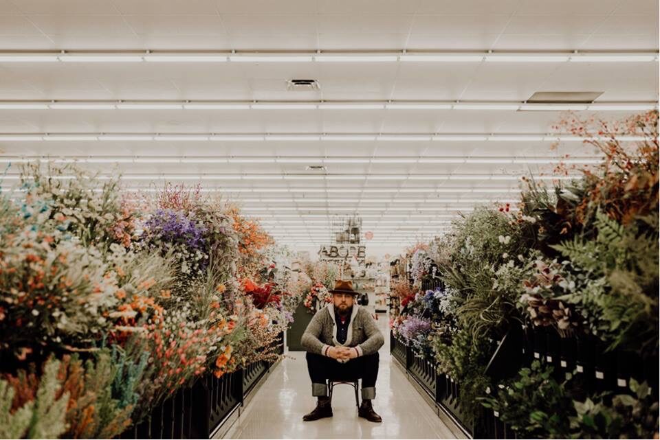 a man sitting in a chair in a flower store